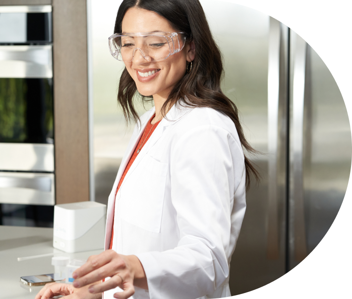Woman in a lab wearing safety glasses looking at test results